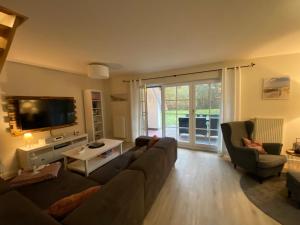 a living room with a couch and a tv at Schwalbennest in Zingst
