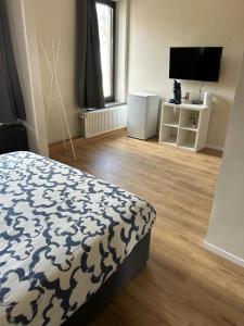 a bedroom with a bed and a flat screen tv at Station 64 A3 Bruxelles-Charleroi-airport in Charleroi