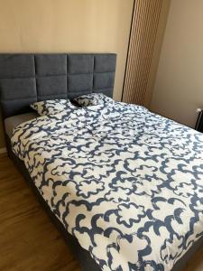 a bed with a blue and white comforter on it at Station 64 A3 Bruxelles-Charleroi-airport in Charleroi