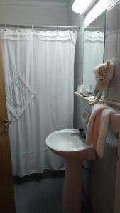 La salle de bains est pourvue d'un lavabo et d'un rideau de douche. dans l'établissement Hotel Perugia, à Necochea