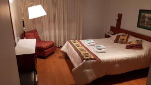 une chambre d'hôtel avec un lit et une chaise dans l'établissement Hotel Perugia, à Necochea