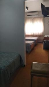 Cette chambre comprend 2 lits et une fenêtre. dans l'établissement Hotel Perugia, à Necochea