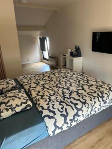 a bedroom with a bed with a black and white comforter at Station 64 A2 Bruxelles-Charleroi-airport in Charleroi