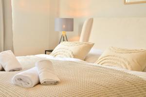 a white bed with two rolled towels on it at MILPAU Bottrop 2 - Modernes und zentrales Premium-Apartment für 4 Personen mit Queensize-Bett und Einzelbetten - Netflix, Nespresso und Smart-TV in Bottrop