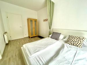 a white bedroom with two beds in it at City Apartment zum Wohlfühlen in Graz