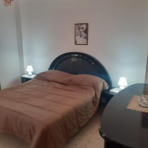 um quarto com uma cama e uma mesa com 2 candeeiros em Casa vacanza Nuvola Rossa KR7 em Crotone