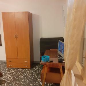 Cette chambre comprend un bureau avec un ordinateur et une armoire. dans l'établissement Casa vacanza Nuvola Rossa KR7, à Crotone