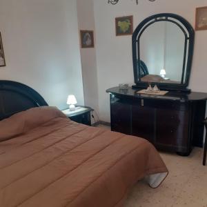 um quarto com uma cama e uma cómoda com um espelho em Casa vacanza Nuvola Rossa KR7 em Crotone