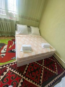 ein Schlafzimmer mit einem Bett mit zwei Platten darauf in der Unterkunft The Silk Road Stopover in Kazarman