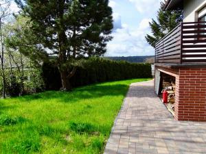 a brick walkway next to a yard with a tree at Zielona Mila in Sępólno Krajeńskie
