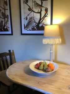 a plate of fruit on a table next to a lamp at Holmlea Cottage in Moffat
