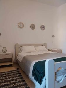 a bedroom with a bed and two clocks on the wall at Papas Apartments in Moírai