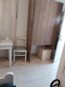a room with a table and a chair and a cabinet at Papas Apartments in Moírai