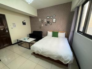 1 dormitorio con 1 cama, 1 silla y 1 mesa en 一中自在居, en Taichung