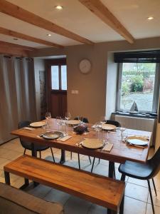 a wooden table with chairs and wine glasses on it at Charmante maison en bord de Rance in Plouër-sur-Rance +13 photos