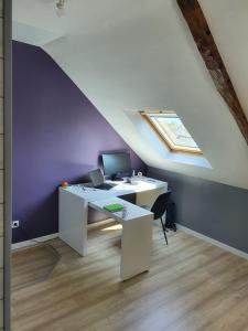 an attic office with a desk with a computer on it at Charmante maison en bord de Rance in Plouër-sur-Rance