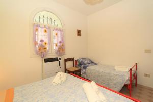 a room with two beds and a dresser with a window at Appennini Villas in Lido di Pomposa