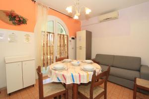 a dining room with a table and a couch at Appennini Villas in Lido di Pomposa
