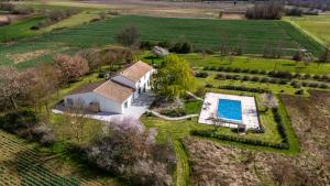 an aerial view of a house with a swimming pool in a field at Chez PhiL in La Pomarède