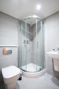uma casa de banho com um chuveiro, um WC e um lavatório. em Garden Apartment - Close to Town Centre - sleeps 6 em Buxton