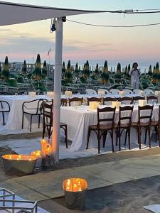 a group of tables and chairs with lit candles at C.R.D.D. Due Torri Riccione in Riccione