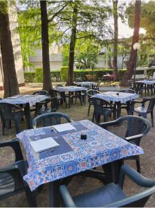 eine Reihe von Tischen und Stühlen in einem Park in der Unterkunft C.R.D.D. Due Torri Riccione in Riccione