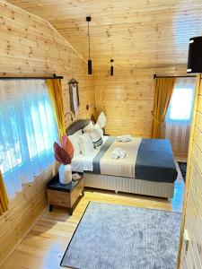キラリにあるCemils Guest Houseの木造キャビン内のベッド1台が備わるベッドルーム1室を利用します。