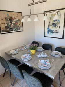- une table à manger avec des chaises et des assiettes dans l'établissement "Moin Moin" - gemütliches Ferienhaus mit Garten und Terrasse für die große Familie, à Grömitz