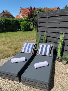 deux oreillers assis sur un banc dans une cour dans l'établissement "Moin Moin" - gemütliches Ferienhaus mit Garten und Terrasse für die große Familie, à Grömitz