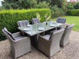 une table avec des chaises en osier et un tableasteryasteryasteryasteryasteryasteryastery astery dans l'établissement "Moin Moin" - gemütliches Ferienhaus mit Garten und Terrasse für die große Familie, à Grömitz 11 autres photos