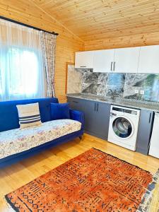 キラリにあるCemils Guest Houseのリビングルーム(青いソファ、洗濯機付)