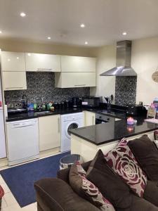 a living room with a couch and a kitchen at Promenade Sea View Apartment in Ballycastle