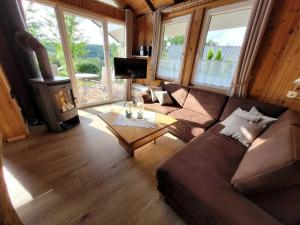 ein Wohnzimmer mit einem Sofa und einem Holzofen in der Unterkunft Ferienhaus Luna mit Saunahaus, Kaminofen, Klimaanlage, schöner Blick im Ferienpark Extertal in Extertal