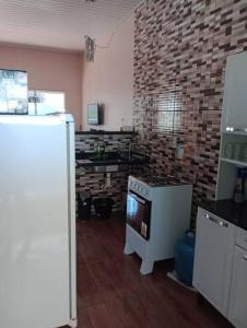 a kitchen with a stove and a brick wall at Apartamento Mobiliado aconchegante - Wi-Fi in Boa Vista