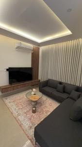 een woonkamer met een bank en een salontafel bij شقق السيف الفندقية in Riyad