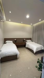 een slaapkamer met 2 bedden in een kamer bij شقق السيف الفندقية in Riyad