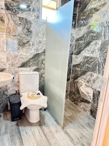 a bathroom with a toilet and a sink at Cemils Guest House in Cıralı