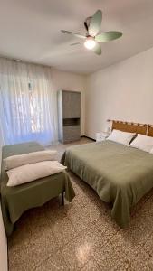 a bedroom with two beds and a ceiling fan at Primo Piano in Moneglia