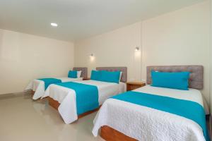 - 2 lits dans un dortoir bleu et blanc dans l'établissement Hostal Plaza by Elvita, à Baños