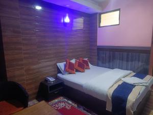a bedroom with a bed with wooden walls and a window at Express Myagdi Hotel Pvt Ltd in Kathmandu