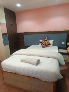 een slaapkamer met een groot bed met witte lakens bij Express Myagdi Hotel Pvt Ltd in Kathmandu