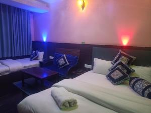 een hotelkamer met 2 bedden en een tafel bij Express Myagdi Hotel Pvt Ltd in Kathmandu