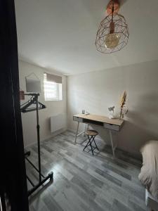 a room with a desk and a table and a lamp at La maison de LYA (lyaroom) 