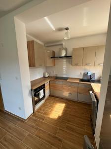 a kitchen with wooden cabinets and a wooden floor at Domek na Skarpie in Wisła