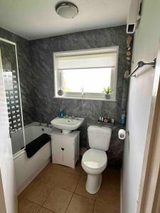 ヘムズビーにあるSunset Chaletのバスルーム(トイレ、洗面台付)、窓が備わります。