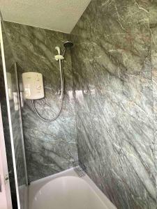a bathroom with a shower and a toilet at 129 Sunset Chalet in Hemsby +8 photos