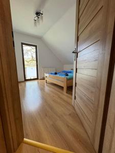 um quarto com uma porta que leva a uma cama em Domek na Skarpie em Wisla