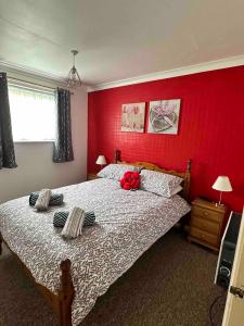ヘムズビーにあるSunset Chaletの赤い壁のベッド付きの赤いベッドルーム