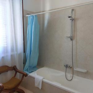 a bathroom with a tub and a shower with a shower curtain at House ALBACHIARA in Otranto