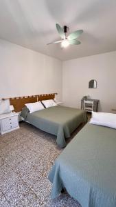 una camera con 2 letti e un ventilatore a soffitto di Primo Piano a Moneglia